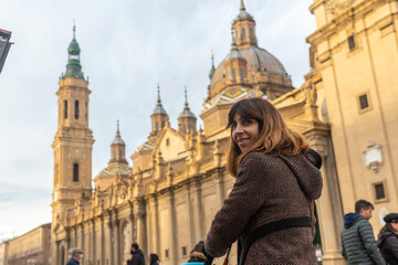 Obraz premium A young woman visiting the Plaza del Pilar in the city of Zaragoza at sunset, Aragon. Spain