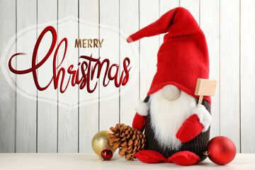 Merry Christmas! Cute gnome and festive decor on table against white wooden background