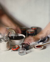 Combination of long exposure and double exposure of hands making blackberry jam