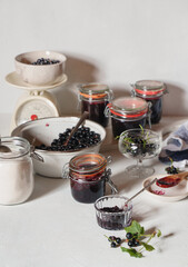Bowl of fresh blackberries, sugar, glass jars with blackberry jam