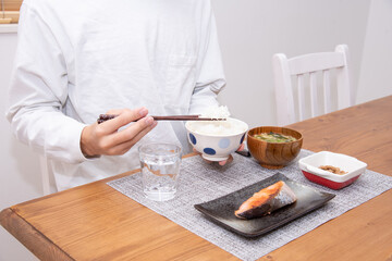 手作りの鮭定食を食べる30代の男性