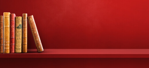 Row of old books on red shelf. Background banner