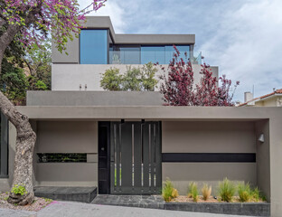 modern house front and wide entrance door by the sidewalk
