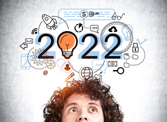 Young handsome businessman is watching at sketch with 2022 sign