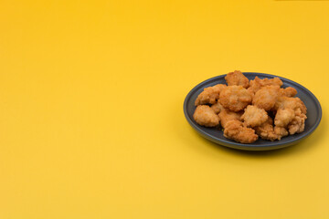 A plate of fried chicken with yellow background