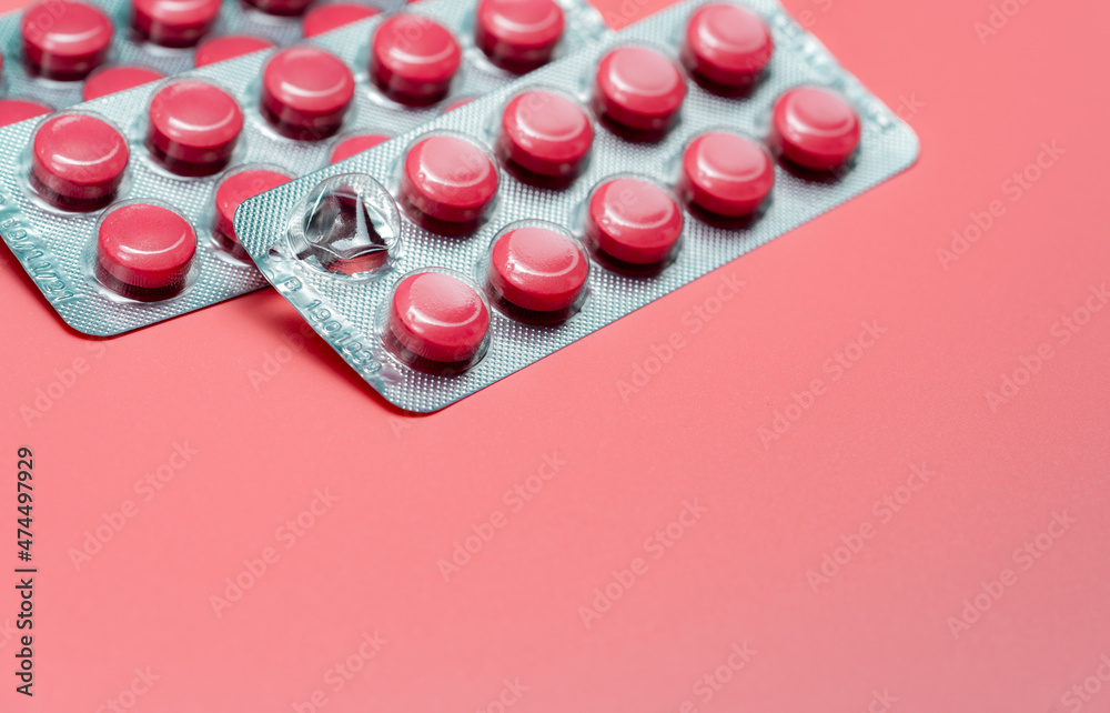 Wall mural pink round tablets pills in blister pack on pink background. painkiller medicine. take pill. pharmac