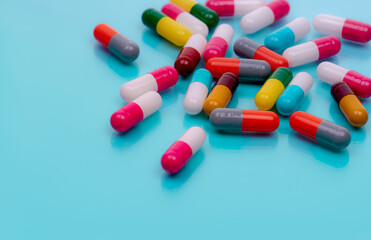 Antibiotic capsule pills on blue background. Prescription drugs. Colorful capsule pills. Antibiotic drug resistance concept. Pharmaceutical industry. Superbug problems. Medicament and pharmacology.