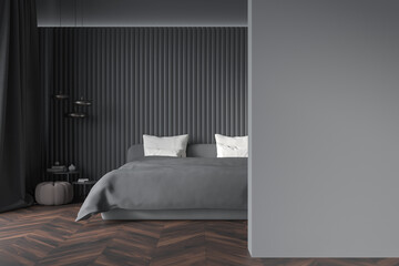 Dark bedroom interior with empty grey wall, bed, coffee table