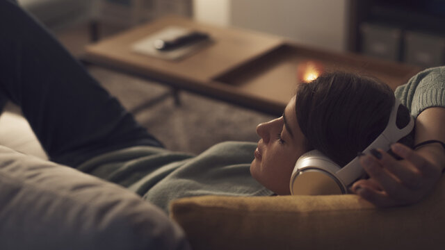 Teenager relaxing on the sofa and listening to music