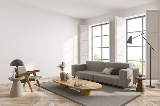White living room interior with sofa and armchair on parquet floor, mockup