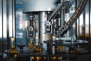 Machine tool puts caps on bottles of hard alcohol drink
