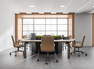 Bright office room interior with panoramic window, six laptops
