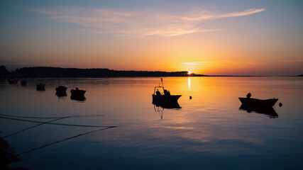 Silhouettes of fishing boats on the Minho River at sunset. The border between Portugal and Spain.