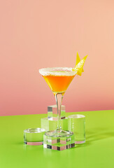 Sidecar classic alcoholic cocktail with cognac, liqueur, lemon juice and ice. Pink and green pop background, copy space