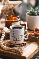 Lifestyle. A cup of tea on a wooden table during the Christmas holidays. The inscription on the mug in Russian: do what you want. Still-life. The concept of home warmth, comfort.