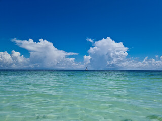 Beautiful, exotic and natural tropical landscape, beach with white sand. Turquoise Indian Ocean on background blue sky with white big clouds on sunny summer day, Zanzibar Island, Afica, Nungwi, Kiweng