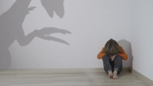Monster silhouette  reflect on wall, child sit alone in corner, fear shadow, conceptual