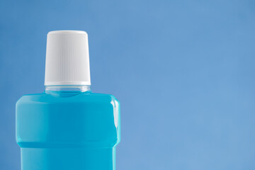 Mouthwash bottle for oral hygiene routine on light blue background