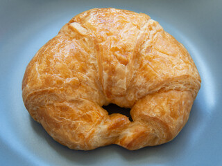 Croissant bread placed on a ceramic plate