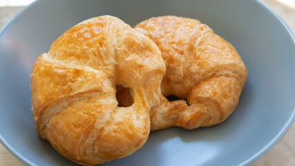 Two Croissant bread placed on a ceramic plate