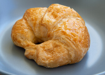 Croissant bread placed on a ceramic plate