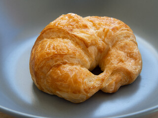 Croissant bread placed on a ceramic plate
