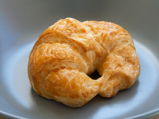 Croissant bread placed on a ceramic plate