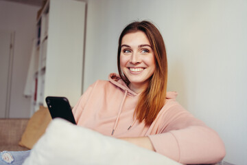 Vivacious young woman relaxing on a couch with a beaming smile