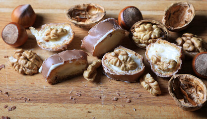 Chocolate dessert with vanilla cream and nuts on a wooden table