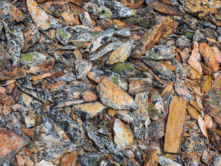 Scattered colored stones, abstract rocky mountain texture. Layered detailed texture of a rocky mountain slope. Geological scattering of stones in close-up.