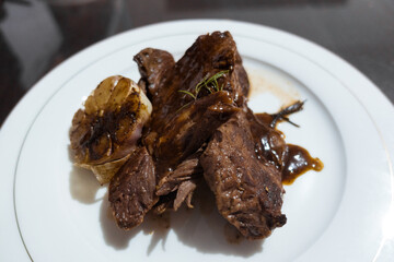 Piece of roast beef with spices served on wooden cutting board