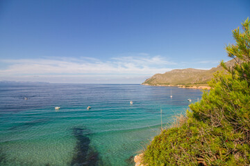Turquoise water, rocky coast line and boats at beautiful beach Cala na clara near Betlém at Mallorca island, Mediterranean Sea, Spain