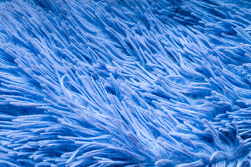 close-up of the villi and pile of a plush plaid or rug of a pale blue color for the decoration of...