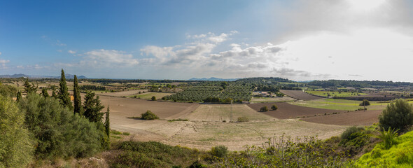 Obraz premium Panoramic view of landscape near Muro, Mallorca island, during October, with arid fields and mediterranean vegetation