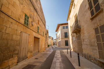 Fototapeta na wymiar Narrow street and mediterranean stone buildings at Muro, Mallorca island, Spain