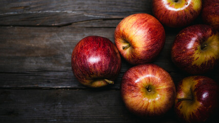 
overhead shot of colorful, ripe apples with copy space on a textured wooden table background
