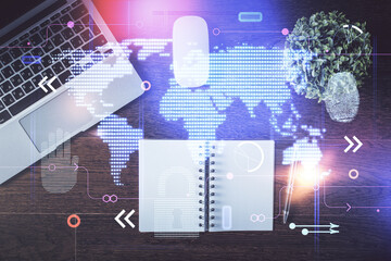 Double exposure of map hologram drawing over study table background with computer. Concept of international network. Top view.