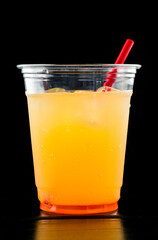 cold orange lemonade in a plastic cup to take away