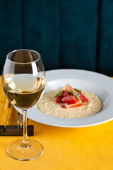 glass of wine and risotto with strawberries in the restaurant