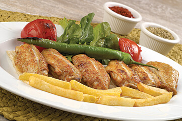 tasty grilled chicken wings on a white dish, top view