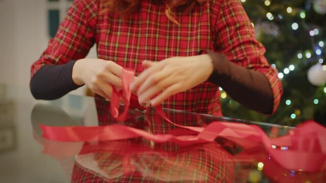 Giovane ragazza prepara il regalo di Natale sul tavolo