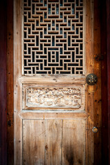 Close-up detail of ancient classic wooden door panel decorated with typical Chinese architecture...