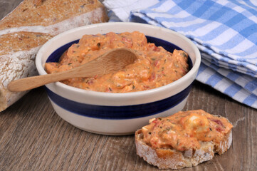 Ktipiti dans un ramequin avec une cuillère en bois à côté d'une tartine de pain en gros plan