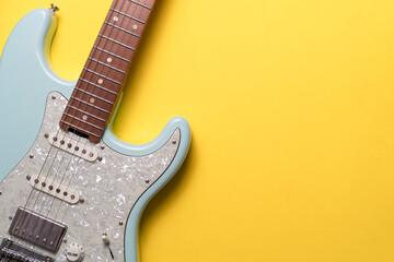Electric guitar on yellow table background, flat lay, music instrument concept