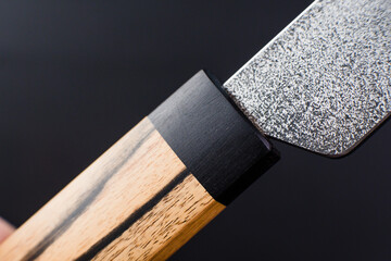 Macro - Exclusive handmade leather craft wooden Skiving knife blade . Close up tanner tool Chartermade. Black background.