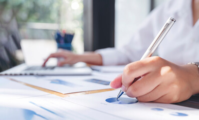 businesswoman working at office with document on her desk, doing planning analyzing the financial...