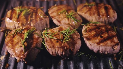 Delicious juicy meat steak cooking on grill. Prime beef fry on electric roaster, rosemary, black pepper, salt. Slow motion.