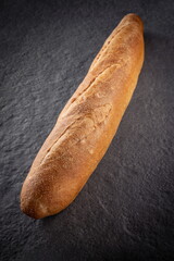 Fresh baked Baguette Loaf on Stone Plate Perspective View