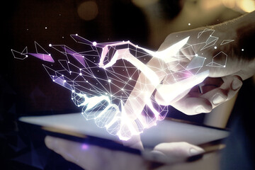 Double exposure of man's hands holding and using a digital device and handshake drawing. Partnership concept.