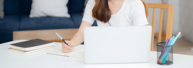 Young asian woman wearing headphone study online with e-learning on desk, girl wearing headset...